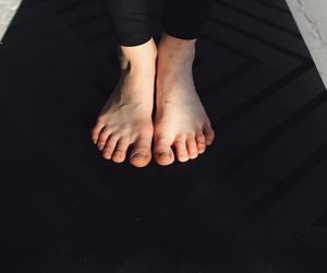 Close-up on hands and feet, showing precise positioning in a yoga pose.