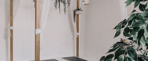 Wide shot of a minimalist, clean yoga studio space with natural light.